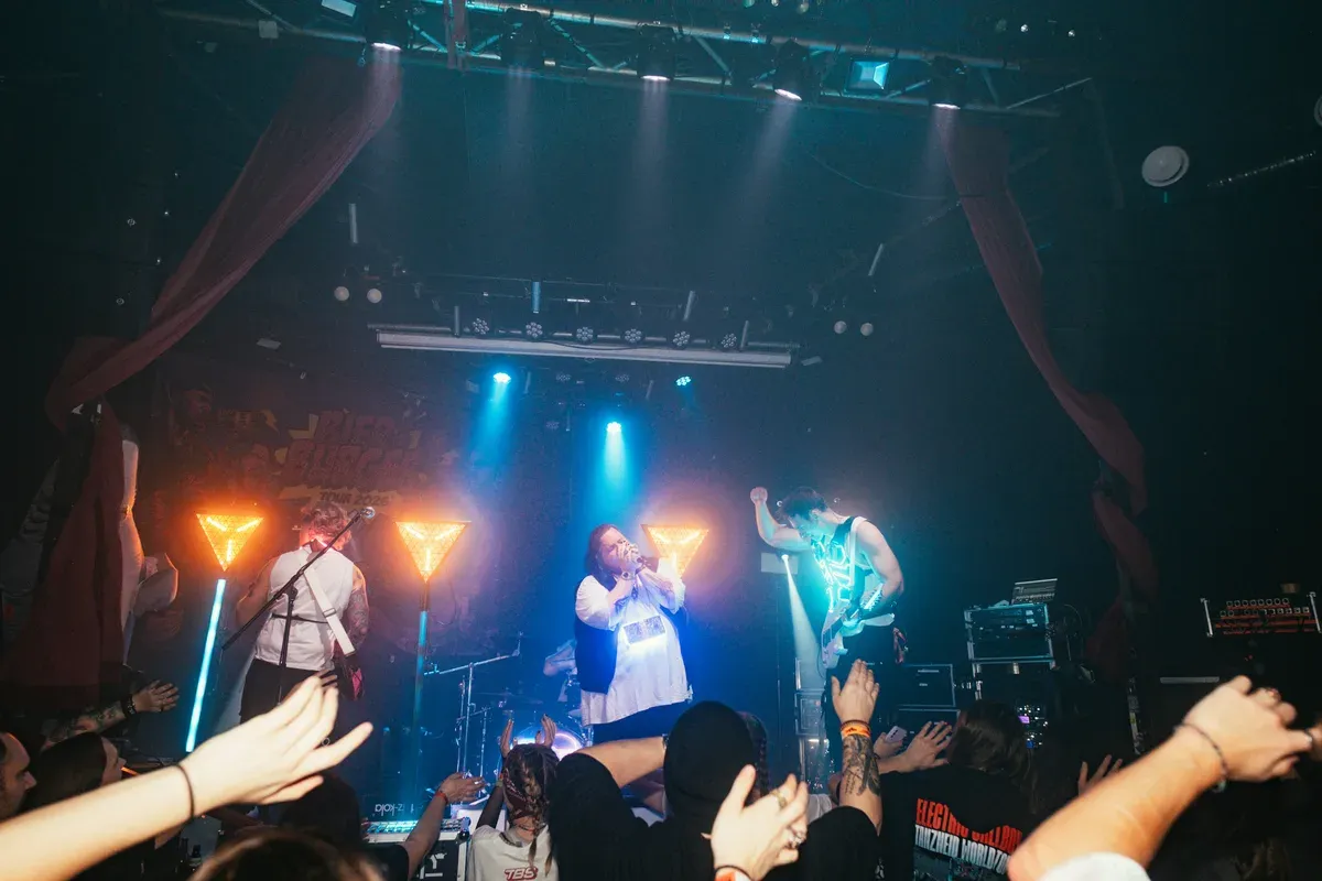 Publikum streckt Haende zur Buehne waehrend die Band spielt